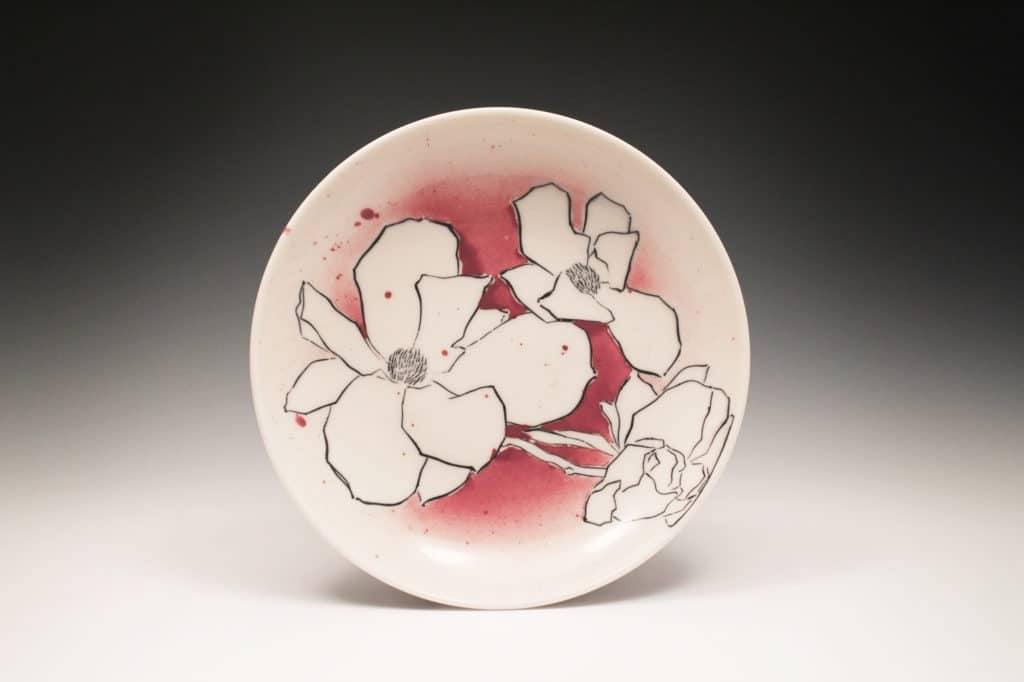 Salad Plate by Nikki Navaille. White plate with black graphic drawings of magnolias and pink gradient background. 2020.